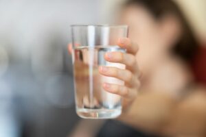 person holding glass of water