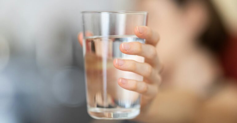 person holding glass of water